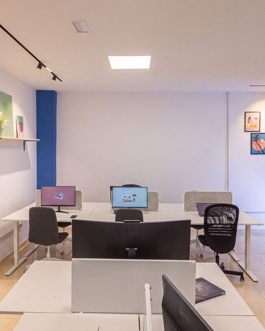 The full FICO coworking room, desks and workstations under daylight